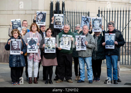 Le famiglie di coloro che sono stati uccisi durante la contestazione di un serie di tiri in Ballymurphy zona di Belfast nell' Agosto 1971 mantenere immagini dei loro cari con i sostenitori al di fuori di Belfast Laganside tribunali, Irlanda del Nord, durante una nuova inchiesta su i loro cari morti. Foto Stock