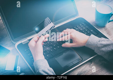 Pagamento online con carta di credito. Mano azienda carta di credito sulla tastiera del notebook Foto Stock