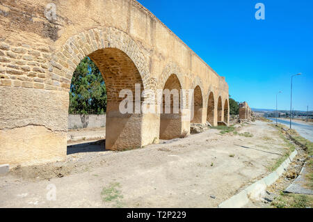 Rovine dell antico acquedotto lungo la strada nei pressi di città romana Uthina (Oudhna). La Tunisia, Nord Africa Foto Stock