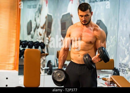 Allestitore treni con bicipiti dumbels. Fitness e crossfit concetto. Foto Stock