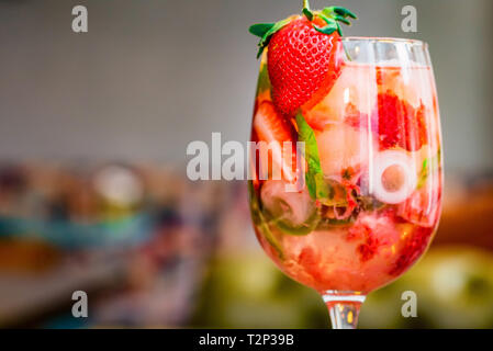 Bicchiere di limonata di fragole con limone, cubetti di ghiaccio e più fresche fragole mature. Messa a fuoco selettiva. Una sana bevanda estiva Foto Stock
