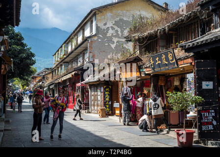 La gente a piedi attraverso una strada storica di Dali Old Town, nella provincia dello Yunnan in Cina Foto Stock