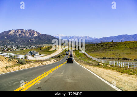 Guidando attraverso il San Bernardino Monti verso Coachella Valley su una soleggiata giornata di primavera; città di montagna sulla sinistra; California del sud Foto Stock