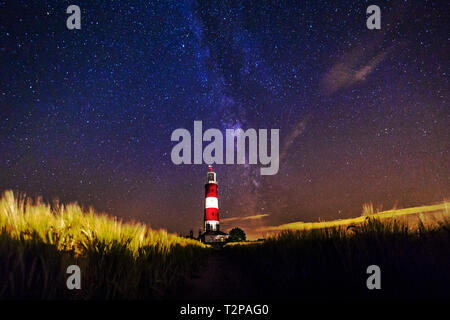 Happisburgh, Norfolk, Regno Unito, 28 Luglio 2016 - Mostra Happisburgh lighthouse di notte con la via lattea sulla Costa North Norfolk, utilizzata per illuminare il cl Foto Stock