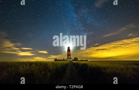 Happisburgh, Norfolk, Regno Unito, 28 Luglio 2016 - Mostra Happisburgh lighthouse di notte con la via lattea sulla Costa North Norfolk, utilizzata per illuminare il cl Foto Stock