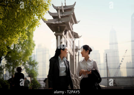 Due sorridenti giovani imprenditrici avente una discussione mentre fuori in città. Foto Stock