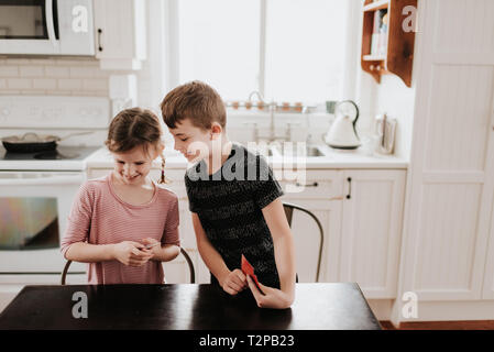 I bambini giocando a carte in cucina Foto Stock