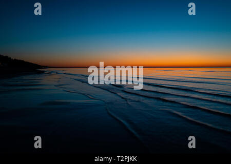 Vivid tramonto da favola in paesi baltici - Tramonto in mare con orizzonte si illumina dal sole - Soluzione satura di giallo, arancione e il colore blu Foto Stock