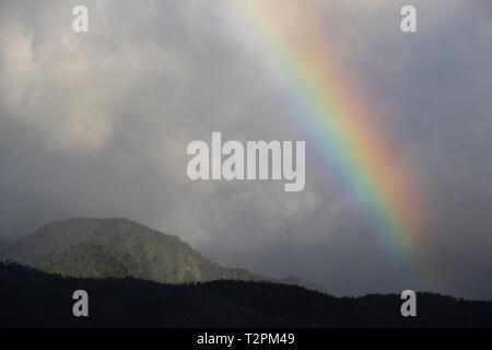 Rainbow oltre il paesaggio montuoso, Dominica, dei Caraibi Foto Stock