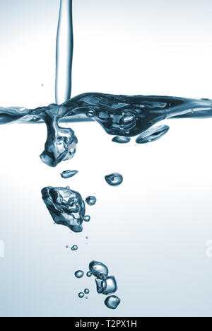 Acqua Splash. Liquido frizzante con bolle versata in recipiente di vetro. Foto Stock