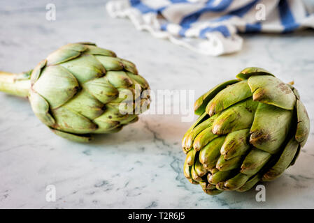 I carciofi su un bancone di marmo Foto Stock