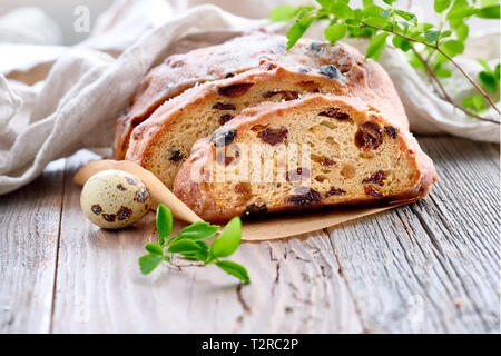 Pane di pasqua (Osterbrot in tedesco). Close-up sul tradizionale pane fruty su legno rustico con foglie fresche e uova di quaglia. Tradizionale dessert tedesco fo Foto Stock