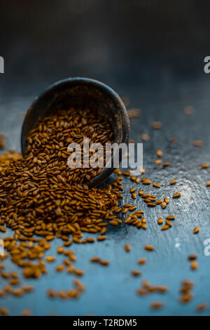 Close up di erba ayurvedica Alsi o ADSI o di semi di lino in un colorato nero ciotola di argilla su una superficie di legno usato in un molti farmaci ayurvedici. Foto Stock
