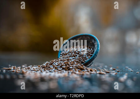 Close up di erba ayurvedica Alsi o ADSI o di semi di lino in un colorato nero ciotola di argilla su una superficie di legno usato in un molti farmaci ayurvedici. Foto Stock