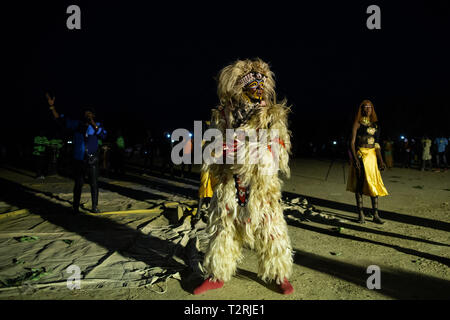 JANJANBUREH, GAMBIA (18/01/2019) - Un Zimba esegue una folla di entrambi i locali e i turisti stranieri in Janjanbureh festival ground. Il Kankurang Janjanbureh Festival è parte di uno sforzo congiunto da parte dell'UE di emergenza del Fondo fiduciario per l'Africa e per i Giovani della Gambia Empowerment progetto per promuovere il turismo in Janjanbureh. Da preservare e celebrare il patrimonio culturale del Kankurang, è la creazione di nuove opportunità economiche per giovani Gambians sotto forma di aumento del turismo. Foto Stock