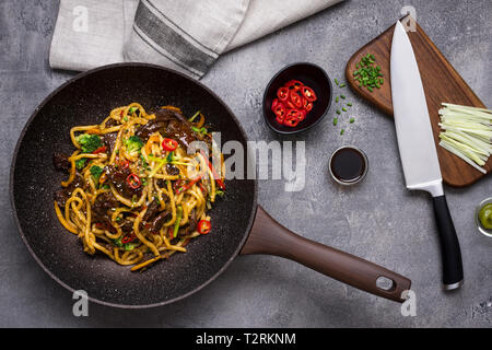 Udon Tagliatelle con manzo e verdure preparato in padella Wok su sfondo scuro Foto Stock