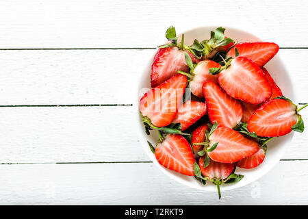 Fresca insalata di fragole, vista dall'alto in una ciotola su sfondo di legno, cibo vegetariano concept Foto Stock