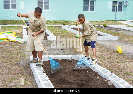 Miami Florida,Liberty City,Piazza,alloggi pubblici,cerimonia,dedicazione,giardino della comunità,complotto,assegnazione,urbano,giardinaggio,movimento verde,ragazzi neri mal Foto Stock