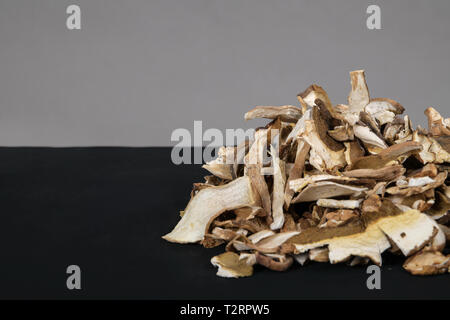 Sacco di fette di secco fungo marrone Boletus Edulis. Fette di funghi secchi su sfondo nero Foto Stock