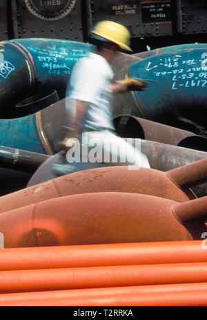 Sfocata del movimento operaio edile si sposta in un cantiere della tubazione Foto Stock