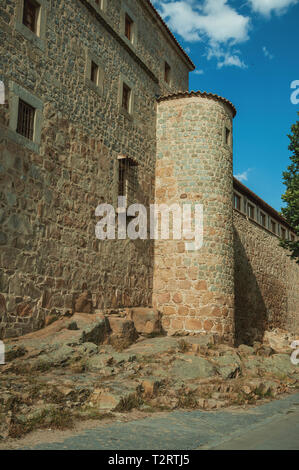Grande città parete con la caratteristica torre rotonda fatta di pietre su terreno roccioso di Avila. Con un imponente muro intorno al quartiere Gotico della città in Spagna. Foto Stock