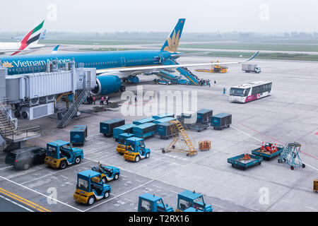 Vietnam Airlines aeromobili aria di carico ai contenitori di carico prima del volo all'aeroporto internazionale di Noi Bai ad Hanoi, Vietnam. Foto Stock