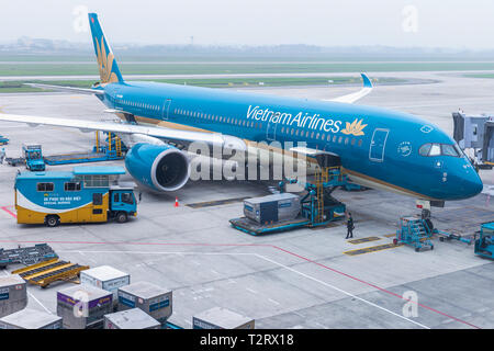 Vietnam Airlines aeromobili aria di carico ai contenitori di carico prima del volo all'aeroporto internazionale di Noi Bai ad Hanoi, Vietnam. Foto Stock