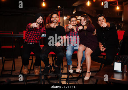 Gruppo di amici indiani seduti al lounge bar, divertimento e riposo. Foto Stock