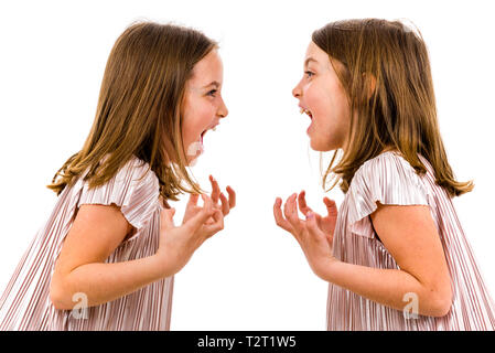 Gemello ragazze stanno cercando in ogni altro e sorridente. Concetto di famiglia e sisterly amore. Il profilo laterale di gemelle in abiti cercando Foto Stock