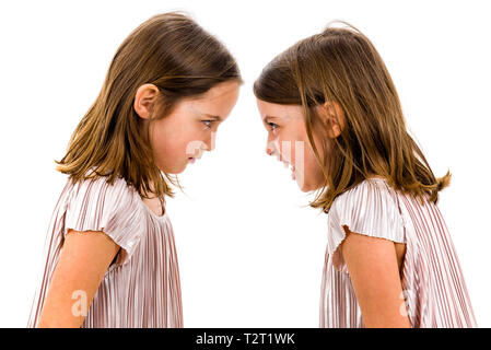 Gemello ragazze sorelle stanno sostenendo a urlare contro l'altra. Arrabbiato ragazze sono grida e urla e sostenendo con espressione emotiva su facce. Fron Foto Stock