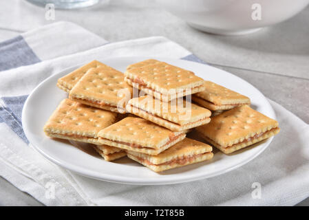 Una piastra di snack di burro di arachidi sandwich fatti con cracker. Foto Stock