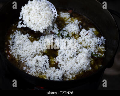 Marzo 31, 2019 - Kiev, Ucraina - Riso visto che viene aggiunto allo stufato..Pilaf è realizzato a partire da carne di agnello o di manzo, riso, le carote e le cipolle con spezie, è popolare non solo tra i popoli turche. Di solito questo piatto è preparato in una speciale in ghisa chiamato pot calderone e sono in diversi formati che vanno da 8 litri a 1000 litri. Abbiamo utilizzato il più piccolo calderone. (Credito Immagine: © Igor Goiovniov/SOPA immagini via ZUMA filo) Foto Stock