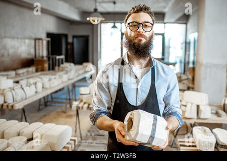 Ritratto di un lavoratore bello in piedi con la forma di gesso alla Fabbricazione ceramica Foto Stock