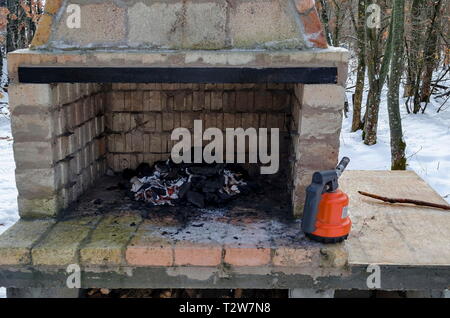 Stufa muratura di mattoni per barbecue nella foresta innevata con carbone di legna sul fuoco vicino alla città, Zavet, Bulgaria, Europa