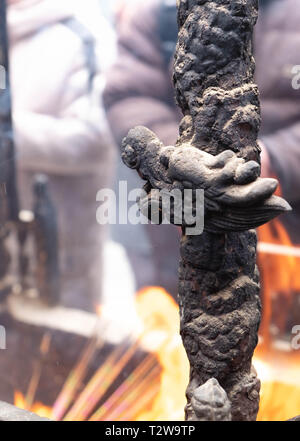 Close up di un altare con dragon carving, incenso bruciatore, joss pot, bastoncini di incenso bruciare con i fumi in un tempio buddista Foto Stock