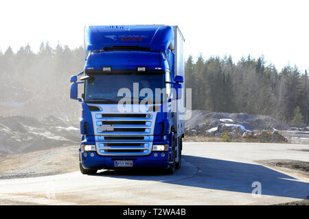 Lieto, Finlandia - 22 Marzo 2019: Blu Scania R560 refrigerato carrello di trasporto su strada con una nuvola di polvere intorno al veicolo. Foto Stock