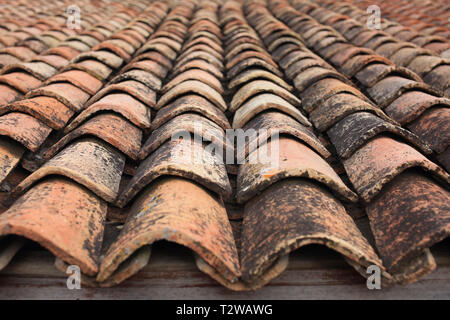 Buona consistenza della vecchia artigianale di tetto di tegole sulla casa di mattoni Foto Stock