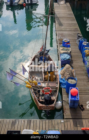 Brighton Marina opinioni UK - Fisherman lavorando sulle sue reti in piccole barche da pesca a est del molo Foto Stock