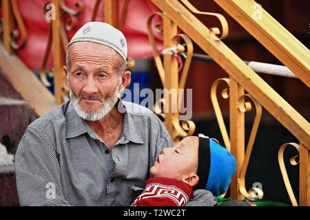 Nonno di Uyghur e nipote di pannolino al bazar-Hotan-Xinjiang-Cina-0078 della città Foto Stock