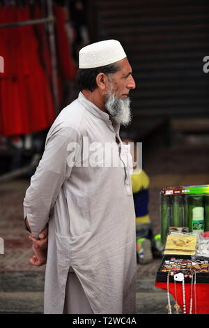 Venditore pakistano che indossa l'Doppa nel bazaar del mercato domenicale della città. Hotan-Xinjiang-Cina-0081 Foto Stock