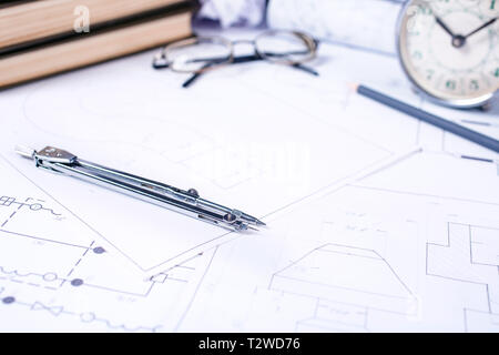 Vecchio orologio con occhiali e bussola su disegni industriali. sfondo architettonico con rotoli di disegni tecnici e blueprint. focu selettiva Foto Stock