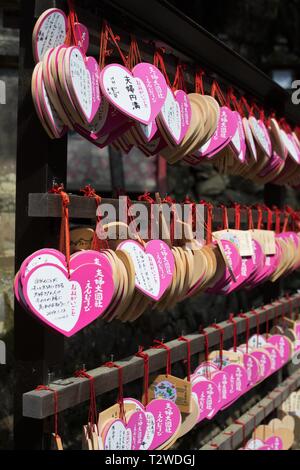 Ema, piccole casette di legno a forma di cuore con placche auguri scritto a mano o preghiere, in corrispondenza di Kasuga Taisha Sacrario di Nara, Giappone. Foto Stock