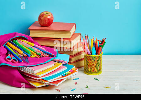 Pasticcio di lavoro sulla tavola dello studente. Scuola e forniture per ufficio telaio Foto Stock