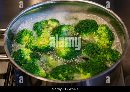 Bollire i broccoletti in acqua. Ortaggi sani Foto Stock