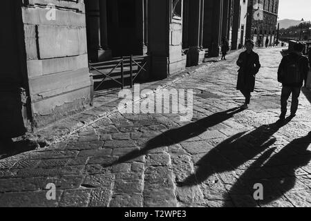 La gente a piedi passato la galleria Ufizzi accanto al fiume Arno in Firenze, Toscana, Italia. Picture Data: domenica 24 febbraio, 2019. Fotografia di Christop Foto Stock