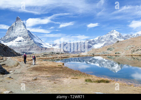 Due escursionisti a piedi unitamente ai lago Riffelsee wit il Cervino in background. Foto Stock