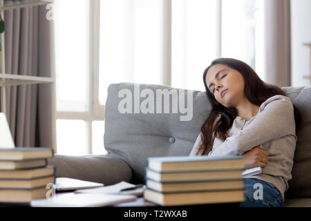 Stanco studente ragazza dorme sul divano affaticato di apprendimento Foto Stock