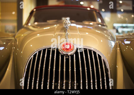 Poznan - Polonia / 28 Marzo 2019 dettaglio del marchio Jaguar sul cofano del bellissimo classico beige XK150 Foto Stock