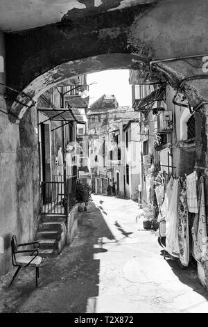 La vecchia strada con case fatiscenti a Catania, Sicilia, Italia. Immagine in bianco e nero Foto Stock