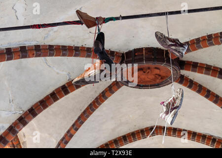 Calzatura tossing (noto anche come Shoefiti) attraverso un filo all'interno del ponte Oberbaum (Oberbaumbrücke) attraverso la Sprea a Berlino, Germania. Foto Stock